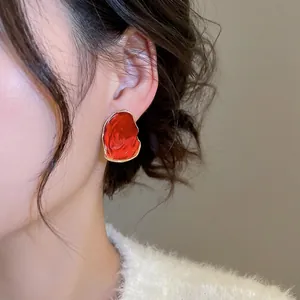 Rote unregelmäßige Lava-Ohrstecker mit Goldrand und minimalistischem Tropföl-Design