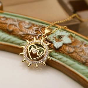 Macro shot of gold sunburst heart pendant with I-Love-U engraving and clear crystals