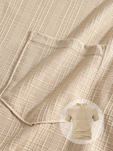Macro detail of beige V-neck men's T-shirt with textured waffle fabric and chest pocket