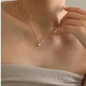 Sterling silver eight-pointed star zircon necklace shown on model's neckline