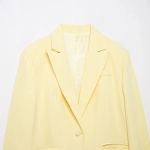 Classic light yellow notched lapel blazer with single button closure and side pockets