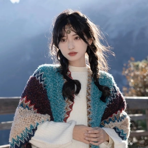 Detail of bohemian knit shawl with zigzag patterns and fringe on mountain landscape