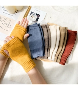 Macro shot of colorful fingerless knitted gloves displayed on a wooden tray