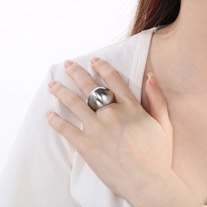Close-up of polished silver wide dome ring worn on finger for a minimalist fashion look