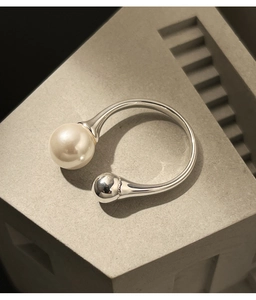 Detail of S925 silver open ring featuring a large white pearl and polished bead