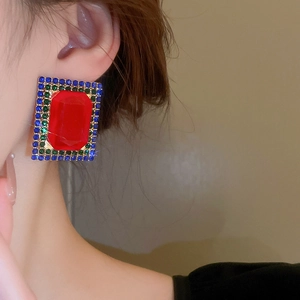 Close-up of vintage geometric earrings with red crystal and multicolor rhinestones