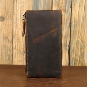 Detailed close-up of dark brown crazy horse leather wallet texture and leather zipper pull
