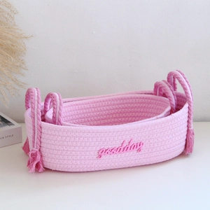 Three-piece set of pink cotton rope storage baskets with fringe detail and embroidery