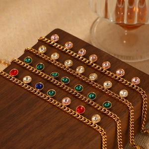 Bracelets élégants en acier doré avec zircons colorés sur présentoir en bois