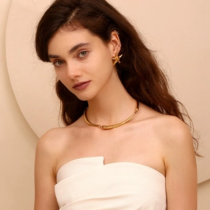 Close-up of golden irregular starfish earrings and choker necklace worn by fashion model