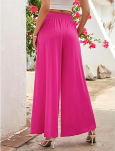 Detail of high waisted rose red wide leg trousers with flowy texture and back view drape