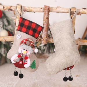 Rustic Christmas stocking with snowman decor and red-black buffalo plaid cuff hanging on wood