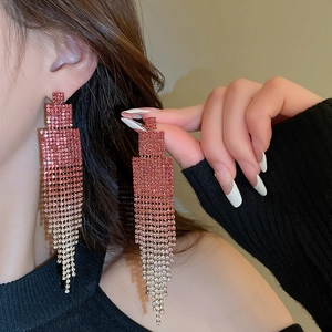 Macro shot of long geometric fringe earrings with pink gradient rhinestones