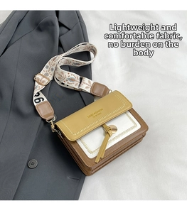 Close-up of tricolor crossbody bag with vintage floral wide strap and gold buckle detail