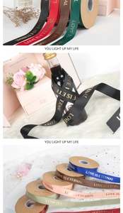 Close-up of multicolored ribbon with gold LOVE IS ETERNAL print for gift wrapping
