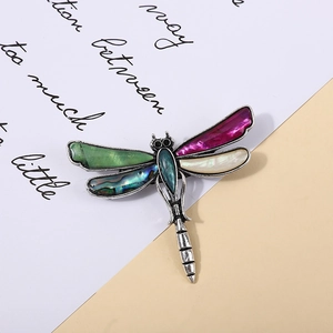 Dettaglio spilla libellula vintage con inserti in madreperla viola e verde cangiante