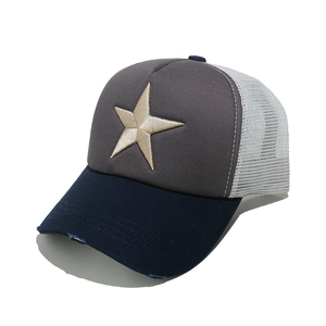 Close-up of distressed brim and star embroidery on a mesh trucker baseball cap