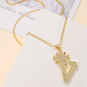 Detail of gold crown letter V pendant with white cubic zirconia on a cable chain