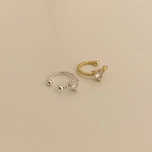 Detailed macro view of heart zircon ear cuffs with twisted rope texture in gold and silver