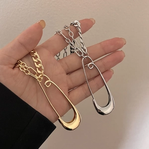 Close-up of hip hop chunky gold-plated chain and large safety pin pendant necklace
