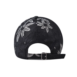 Detail of classic black baseball cap featuring intricate lace flower patterns and silver buckle