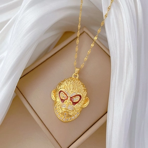 Elegant gold monkey pendant necklace with sparkling rhinestones and red enamel eyes