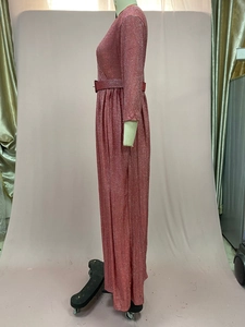 Détail de la robe maxi plissée rose à manches longues avec dorure et tissu brillant