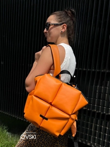 Détails du sac à dos matelassé orange avec zips argentés et bretelles rembourrées