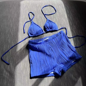 Detail shot of electric blue crinkle fabric texture on bikini top and shorts set