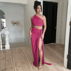 Detailed view of magenta one-shoulder crop top and high-slit long skirt with elegant draping