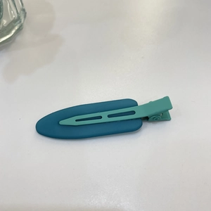 Detail of a matte candy color hair clip featuring a blue and green split design