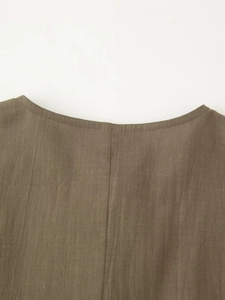 Close-up of the linen fabric texture and neck seam detail on the dark brown blouse