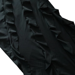 Détail de la robe noire présentant des bords à volants élégants et une texture douce
