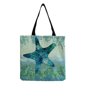 Foldable canvas tote bag featuring a blue and green starfish print on wave patterns