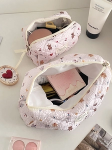 Détail de la trousse à maquillage rose matelassée avec motifs ours et texture douce