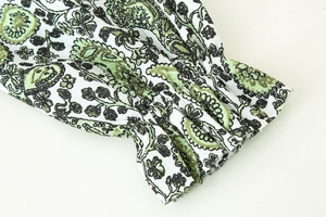 Detailed macro view of elasticated cuffs on a paisley print blouse with floral patterns
