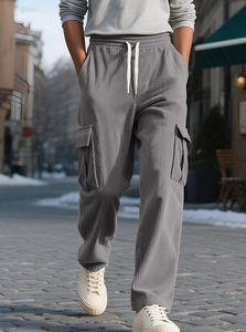 Detailed close-up of grey corduroy cargo pants with white drawstring and side pockets