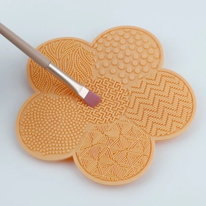 Macro detail of pink flower silicone makeup brush cleaning mat with various textures