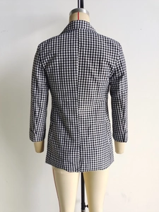 Detail of the back-tailored seams on a black and white checkered slim-fit blazer