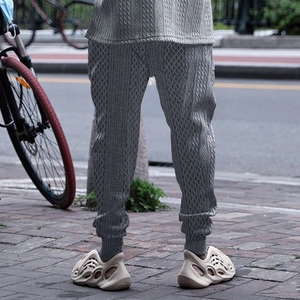Detailed view of grey textured knit joggers with elastic cuffs and jacquard pattern