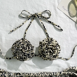 Detail of leopard print bikini top featuring 3D fabric rose floral accents and ties