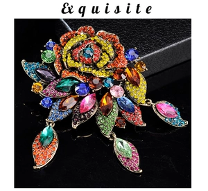 Detailed macro view of vintage gold flower brooch with colorful rhinestones and leaf pendants