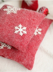 Close-up of red and white knitted Christmas snowflake pillow cover texture detail
