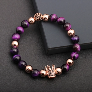 Detailed shot of purple tiger eye stone beads with rose gold crown and black zircon charm