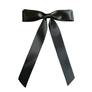 Detail of silky black satin ribbon double bow hair clip with elegant long streamers