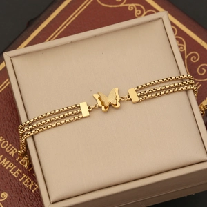 Elegant gold butterfly multi-layer bracelet displayed on a beige leather jewelry box