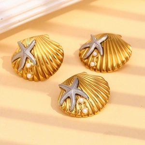Detail of 18K gold-plated shell and silver starfish earrings with white pearls