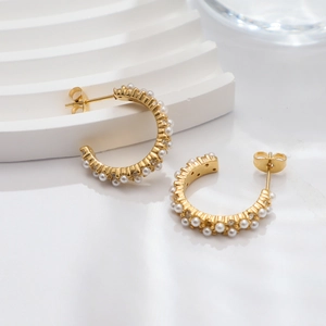 Detail of 18k gold plated stainless steel C-shaped earrings with inlaid white pearls