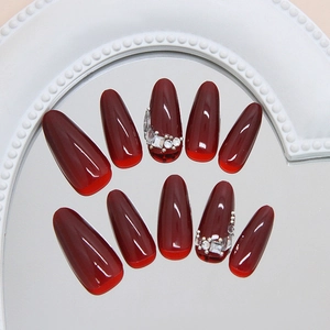 Handmade wine red press-on nails with long oval shape and luxury rhinestone accents
