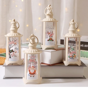 Close-up of four cream LED Christmas lanterns with festive patterns on decorative books